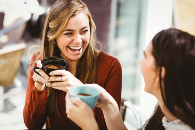 コーヒーを飲みながら談笑する女性