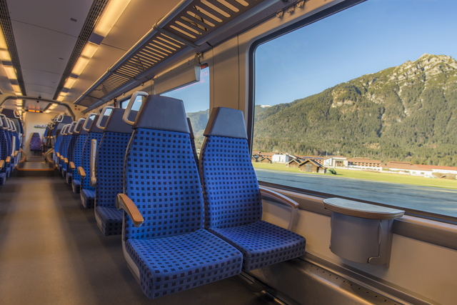 Comfortable chairs on a modern german train, with beautiful alpine view through the window