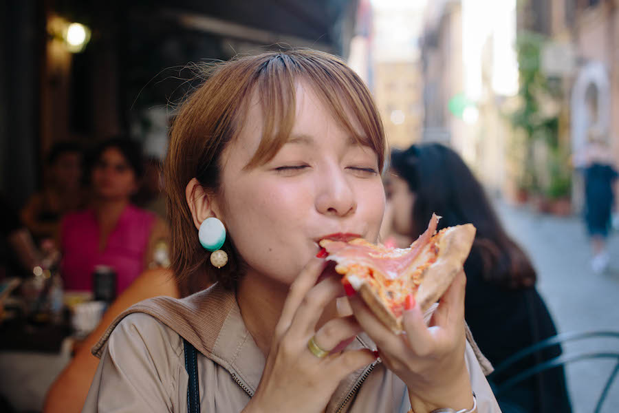 イタリアでピザを食べる女性