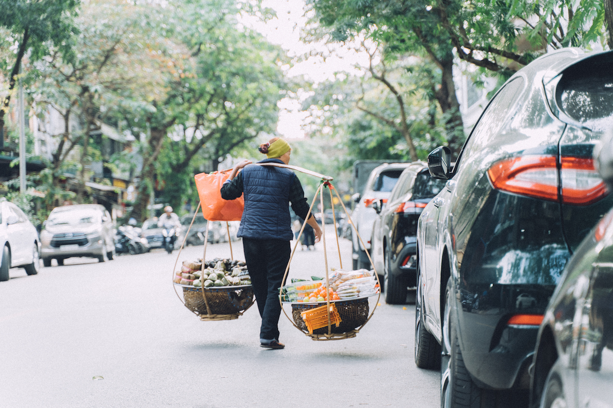 ベトナムの首都ハノイの街並みで天秤棒を担ぐ人