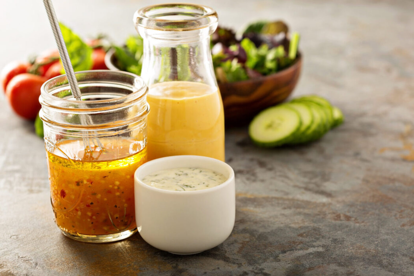 Variety of homemade sauces and salad dressings in jars including vinaigrette, ranch and honey mustard