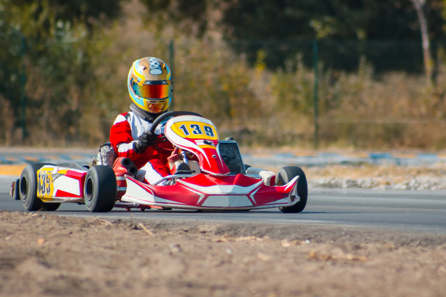 Karting - driver in helmet driving on kart circuit